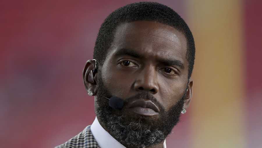 FILE - Broadcaster Randy Moss sits on the sideline before an NFL football game between the San Francisco 49ers and the Los Angeles Rams, Monday, Nov. 15, 2021, in Santa Clara, Calif. (AP Photo/Scot Tucker, File)