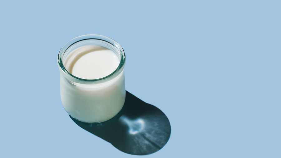 glass of organic fresh milk glass of milk on blue background dairy, grow and drink concept minimal flat lay style top view, copy space